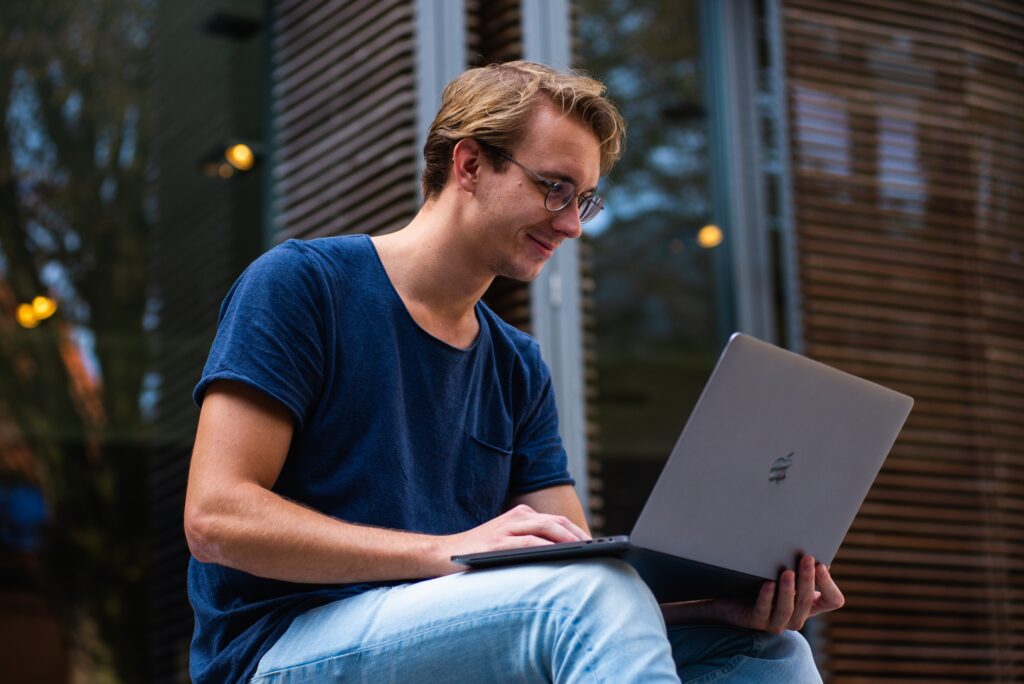 Person working on a laptop, outside.